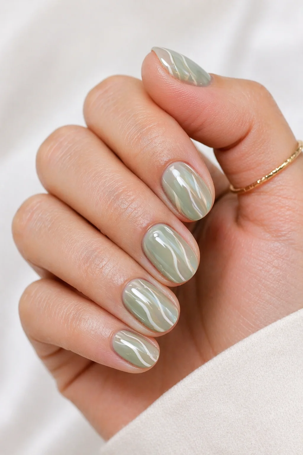 abstract swirl short nail ideas vertical white swirls on sage green creating length illusion on short almond nails 2026